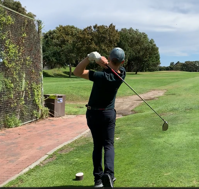 Learning how to overcome anxiety: A golfer thinking powering through a shot after overcoming anxiety on the first tee.